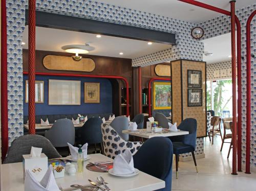 卡拉奇Ambiance Boutique Art Hotel Karachi的一间带桌椅的餐厅以及火车