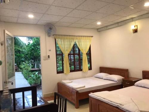 永隆南青民宿的一间卧室设有两张床和窗户。