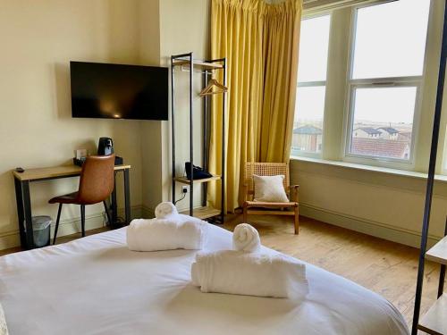 安斯特拉瑟Balcomie Links Hotel的酒店客房,配有带毛巾的床