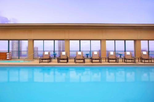 杰克逊维尔杰克逊维尔滨河凯悦酒店的酒店设有带椅子和窗户的游泳池