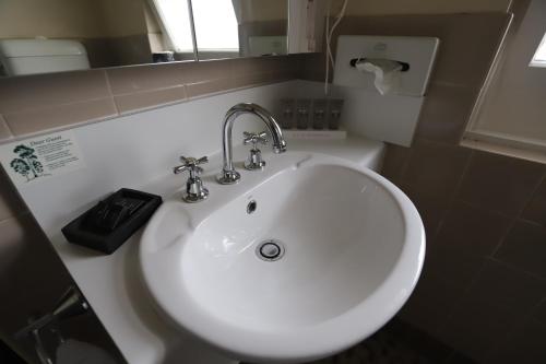考拉Townhouse Motel Cowra的浴室设有白色水槽和镜子