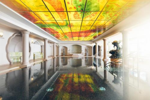 上陶恩Hotel Steiner Superior的一间拥有彩绘天花板和水池的客房