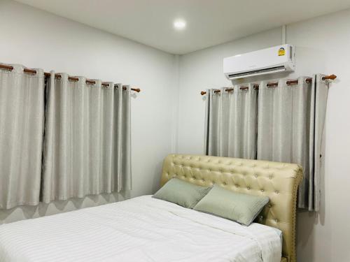 素可泰Phu Thai Resort的一间卧室设有两张床,墙上设有加热器。