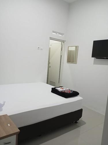 班图尔Srikandi Baru Inn Blok O的白色的客房配有镜子和床