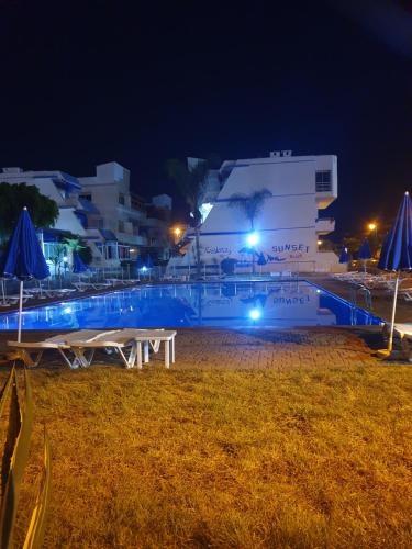 穆罕默迪耶Résidence SUN SET BEACH à 200 m de mer的白色的建筑,夜晚有蓝色的灯光