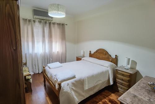 佩纳科瓦Apartamento Mondego的一间卧室配有一张带白色床单的大床