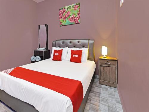 珍南海滩OYO Home 90348 Inspire Rooms的一间卧室配有一张带红色枕头的大床