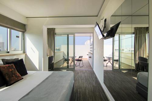 尼科西亚Phaedrus Living: Luxury Suite Nicosia 503的一间卧室配有一张床,客厅设有阳台