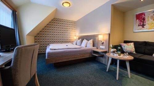 维林根Hotel Garni "Zur Alten Post"的酒店客房,配有床和沙发