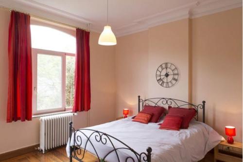 斯帕赫尔米娜度假屋的一间卧室配有一张带红色枕头的床和一扇窗户