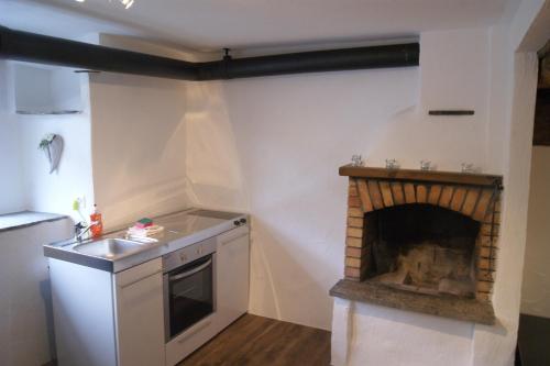 波斯基亚沃Charming 3½ room cottage in Valposchiavo的一间位于客房角落的带壁炉的厨房