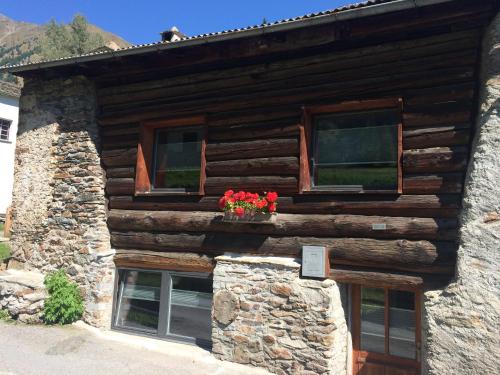 波斯基亚沃Charming 3½ room cottage in Valposchiavo的窗户上鲜花的小木屋