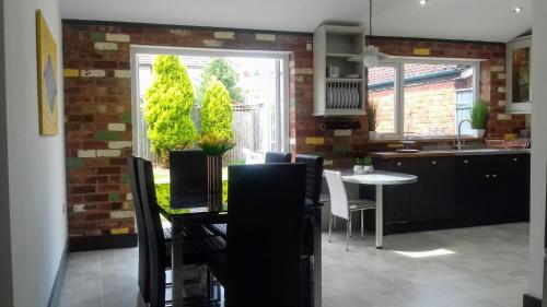 考文垂Stunning & Spacious Family Home. Midlands location的一间带桌椅的厨房和一间用餐室