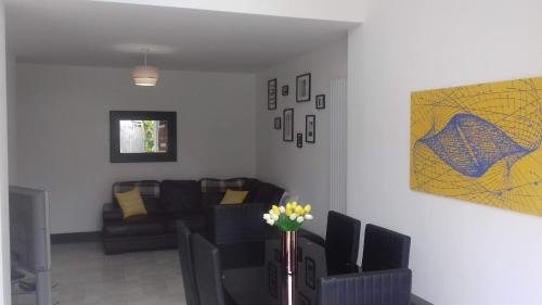 考文垂Stunning & Spacious Family Home. Midlands location的客厅配有沙发和鲜花桌