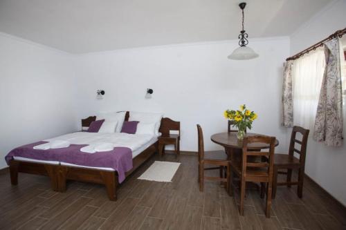 Kovács tanya - falusi szálláshely的卧室配有一张床和一张桌子及椅子