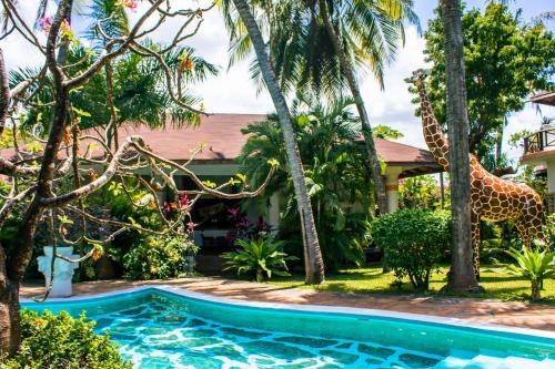 马林迪非洲度假别墅酒店的庭院里带游泳池和长颈鹿的房子