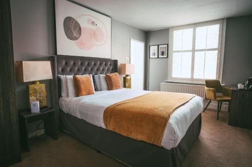 克努斯福德玫瑰和皇冠酒店的一间卧室设有一张大床和一个窗户。