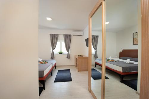 PotpićanHotel Potpican的一间卧室配有两张床和镜子