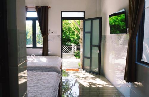 潘郎Hải An Homestay - Garden by the Beach的一间卧室设有一张床和一个滑动玻璃门