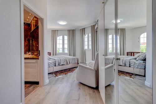 阿德耶Luxury villa El Duque Ocean View的一间白色卧室,配有两张床和镜子