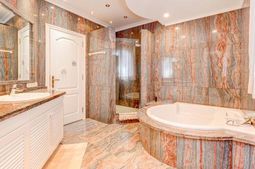 阿德耶Luxury villa El Duque Ocean View的带浴缸和盥洗盆的浴室