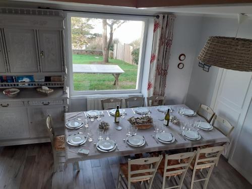 朗西厄Maison vue exeptionnelle sur la mer的餐桌,配有盘子和酒杯