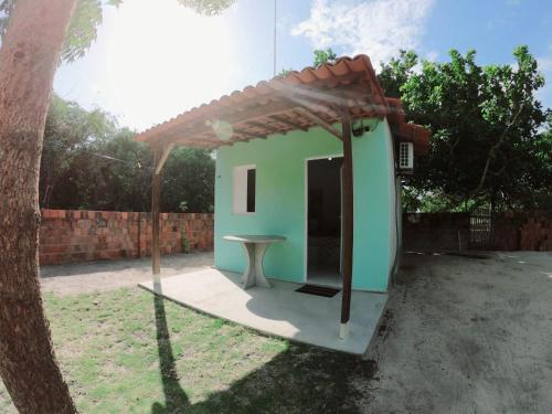 CruzMila chalé的一座小绿色房子,在院子里设有桌子