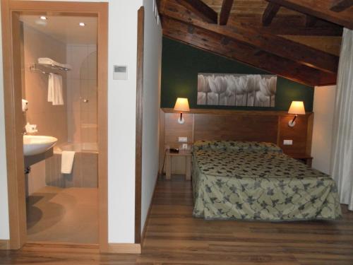 米拉格罗斯米拉格罗斯力拓里亚萨酒店的一间卧室配有一张床,浴室设有水槽