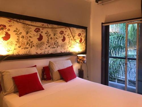 圣路易斯Palma Hostel的一间卧室配有一张带红色枕头的床和一扇窗户