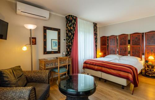 施韦尔姆穆莱泰奇酒店的一间卧室配有一张床、一张沙发和一张桌子