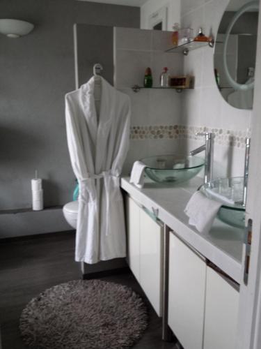 南希Chambres d'hôtes Olry的浴室设有挂在镜子上的白色长袍