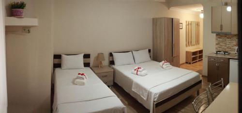 巴统Hotel Tao的小客房内的两张床,配有白色床单
