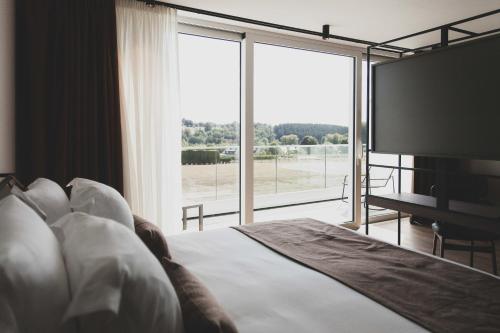 弗朗科尔尚Roannay - Francorchamps的一间卧室设有一张大床和一个大窗户