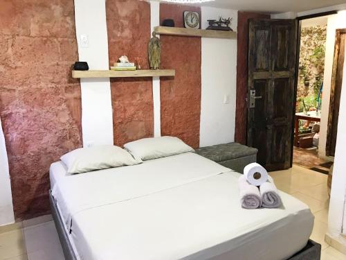 卡塔赫纳Casa Mamá Waldy New的卧室配有白色床和毛巾