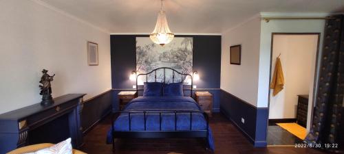 La Roche-DerrienTy Madelez, Chambres de charme, Gîtes, Crêperie et Spa的一间卧室配有蓝色的床和吊灯。