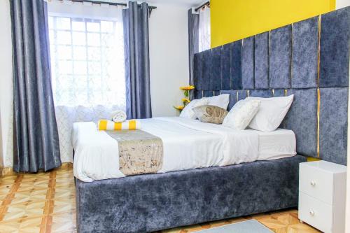 KiambuThe Gem - Kiambu road 1 bedroom的一间卧室配有一张大床和蓝色床头板
