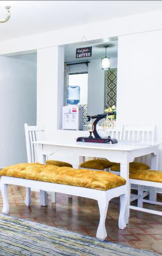 KiambuThe Gem - Kiambu road 1 bedroom的一张带长凳的白色桌子,上面有缝 ⁇ 机