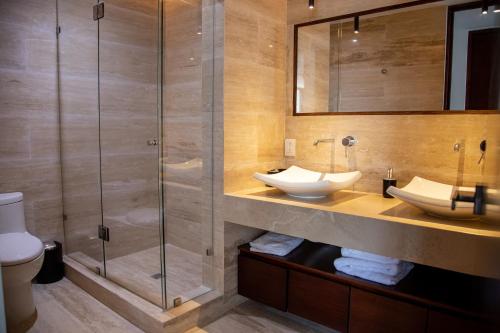图卢姆Kiin Tulum, Luxury Suites的一间带两个盥洗盆和淋浴的浴室