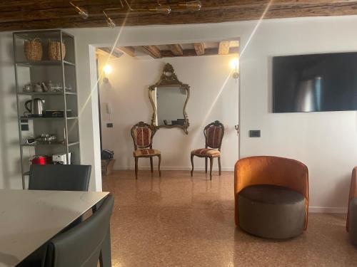 威尼斯Ca' ai Sospiri的客厅配有两把椅子和镜子