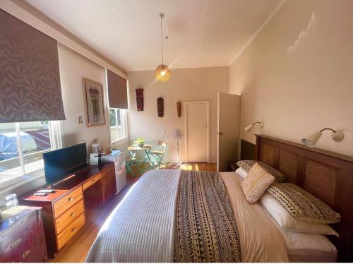 WairoaThe Clyde Hotel的一间卧室配有一张大床和电视