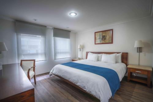 墨西哥城方尖碑套房酒店的酒店客房设有一张大床和两个窗户。