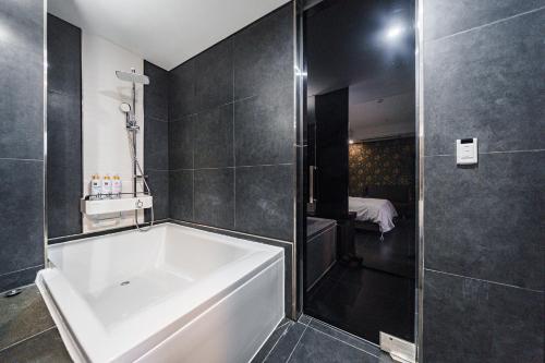 首尔Starhills Hotel的浴室配有白色浴缸和淋浴。