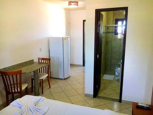 纳塔尔倍加弗洛尔旅馆的客房内的厨房配有桌子和冰箱