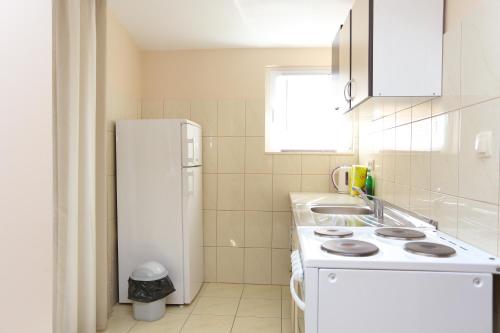 泰斯Apartments by the sea Nemira, Omis - 17039的白色的厨房配有水槽和冰箱
