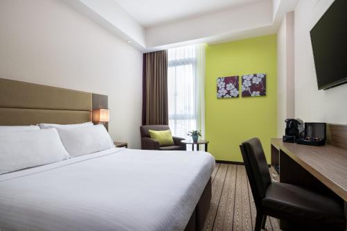 新加坡Hotel Traveltine的配有一张床和一把椅子的酒店客房