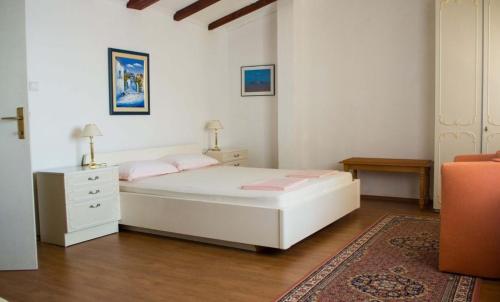 格鲁达Apartments and rooms by the sea Molunat, Dubrovnik - 17143的卧室配有白色床和粉红色枕头