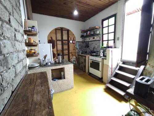 穆库热Hostel Mucugê的厨房配有桌子、炉灶和冰箱。