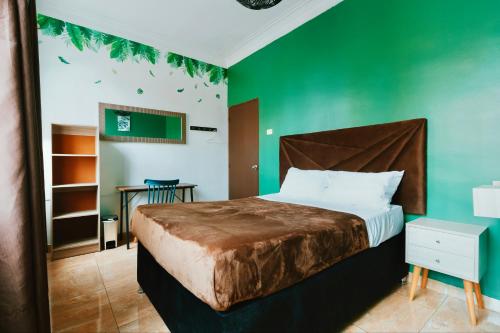 利马The Secret Garden Hostel的一间卧室配有一张带绿色墙壁的床