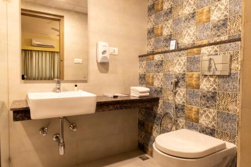 蒂鲁帕蒂Starlit Suites Tirupati的一间带水槽、卫生间和镜子的浴室