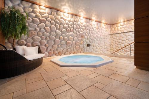 凯尔采奥德赛健康温泉俱乐部酒店的客房内的带按摩浴缸的浴室